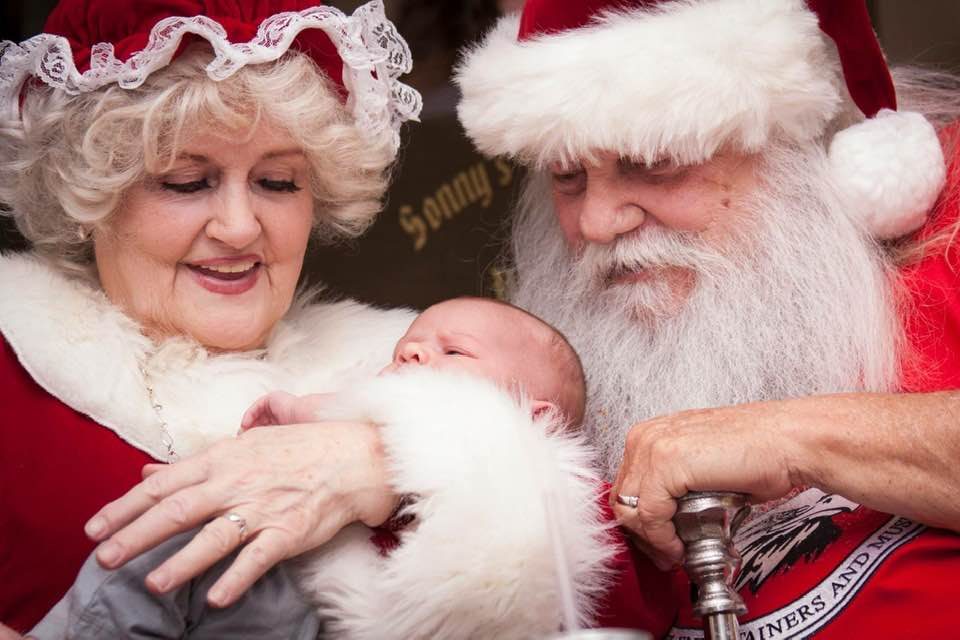 Santa and Mrs. Claus holding a baby