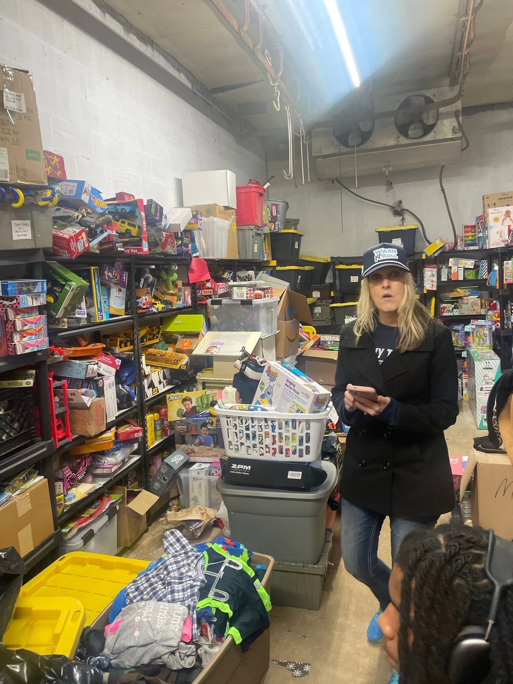 A volunteer among shelves of donated toys at Santa’s Workshop