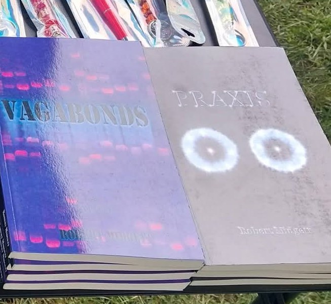 Stacks of Vagabonds and Praxis on a table at an outdoor book event